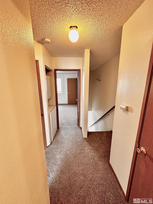 4985 W 7th St Unit 11, Reno, NV 89503 - hallway with an upstairs landing, carpet floors, a textured ceiling, and washer / clothes dryer