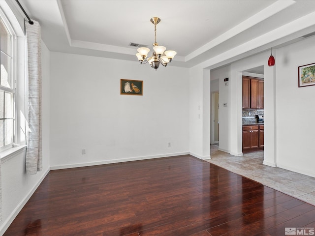 7730 Opal Blf, Reno, NV 89506 - spare room featuring a tray ceiling, a chandelier, light wood-style floors, and baseboards