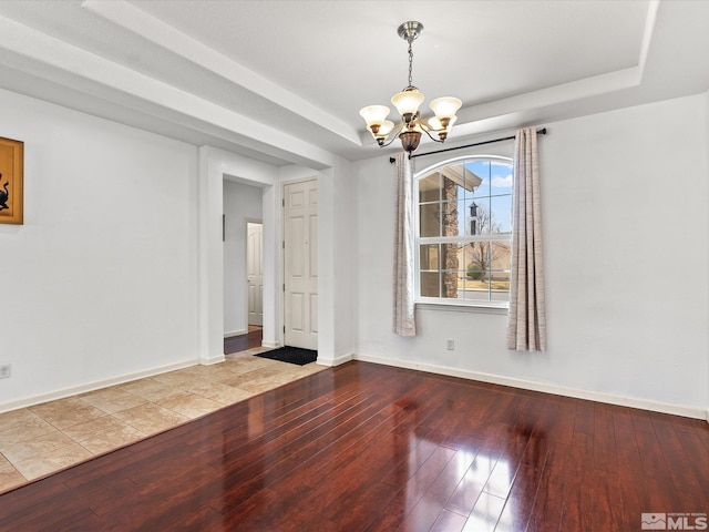 7730 Opal Blf, Reno, NV 89506 - unfurnished room with a raised ceiling, a chandelier, wood-type flooring, and baseboards