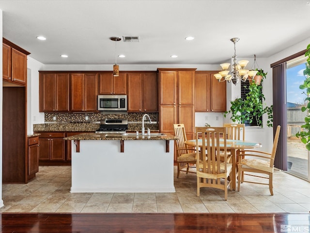 7730 Opal Blf, Reno, NV 89506 - kitchen with stainless steel appliances, a chandelier, dark stone countertops, tasteful backsplash, and recessed lighting