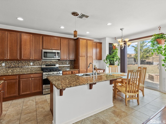 7730 Opal Blf, Reno, NV 89506 - kitchen with appliances with stainless steel finishes, a sink, a chandelier, tasteful backsplash, and dark stone countertops
