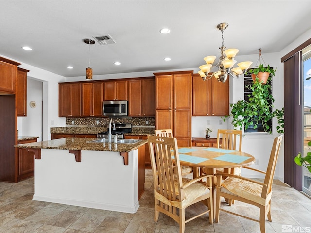 7730 Opal Blf, Reno, NV 89506 - kitchen featuring appliances with stainless steel finishes, tasteful backsplash, a chandelier, dark stone counters, and a breakfast bar