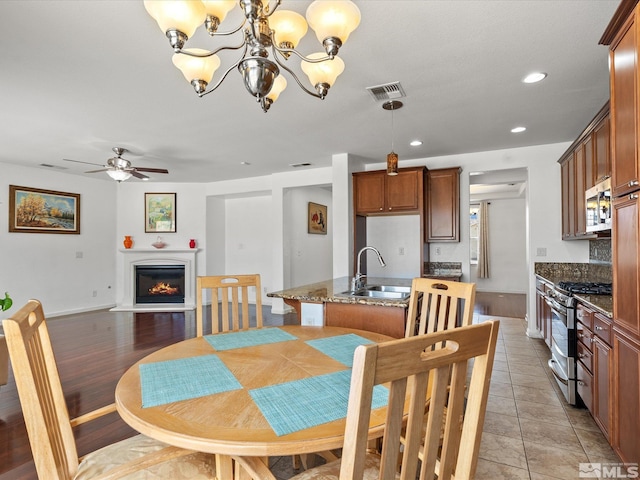 7730 Opal Blf, Reno, NV 89506 - dining room with a ceiling fan, a glass covered fireplace, a chandelier, recessed lighting, and light tile patterned flooring