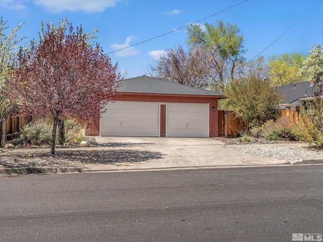 garage featuring fence and driveway