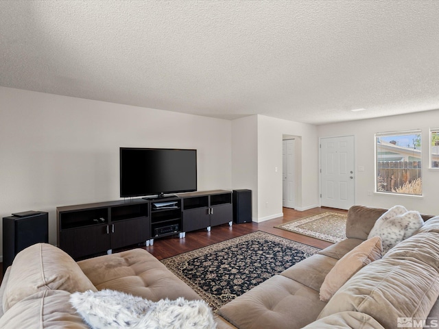 living area with wood finished floors, a textured ceiling, and baseboards