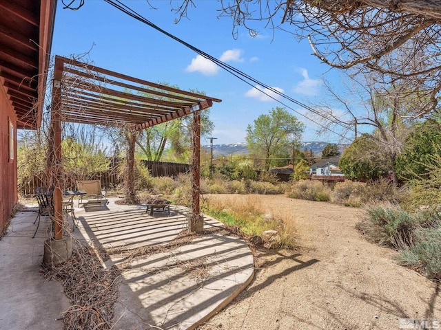 view of yard with a pergola, a patio, an outdoor fire pit, and fence