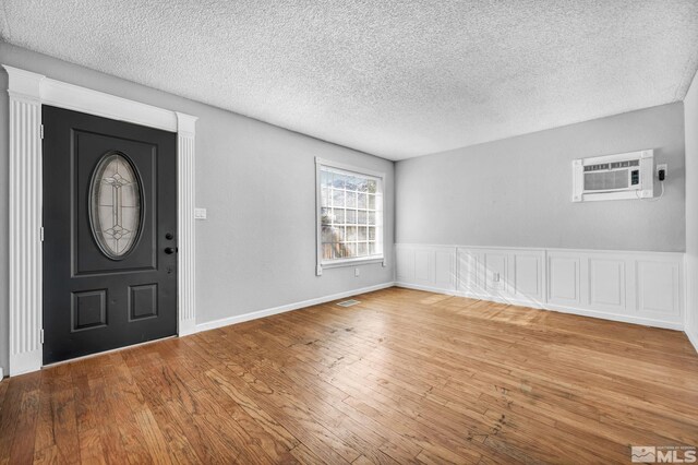 6735 Peppermint Dr, Reno, NV 89506 - entryway with a wall unit AC, light wood-type flooring, and a textured ceiling