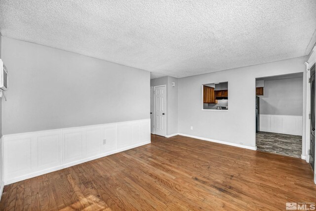 6735 Peppermint Dr, Reno, NV 89506 - empty room featuring wood finished floors, a textured ceiling, and wainscoting