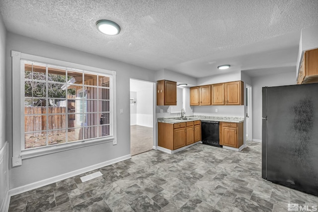 6735 Peppermint Dr, Reno, NV 89506 - kitchen with black appliances, baseboards, light countertops, brown cabinetry, and a textured ceiling