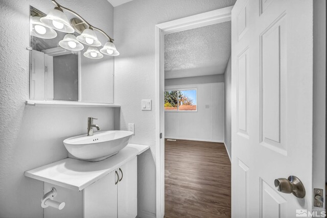6735 Peppermint Dr, Reno, NV 89506 - bathroom with wood finished floors, a textured ceiling, baseboards, a textured wall, and vanity