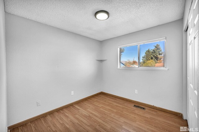 6735 Peppermint Dr, Reno, NV 89506 - empty room featuring wood finished floors, a textured ceiling, and baseboards