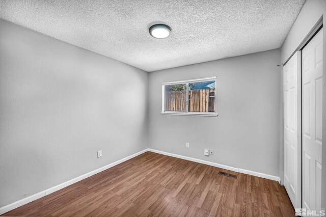 6735 Peppermint Dr, Reno, NV 89506 - unfurnished bedroom featuring a closet, wood finished floors, baseboards, and a textured ceiling