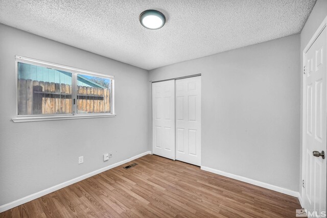 6735 Peppermint Dr, Reno, NV 89506 - unfurnished bedroom with a textured ceiling, baseboards, wood finished floors, and a closet