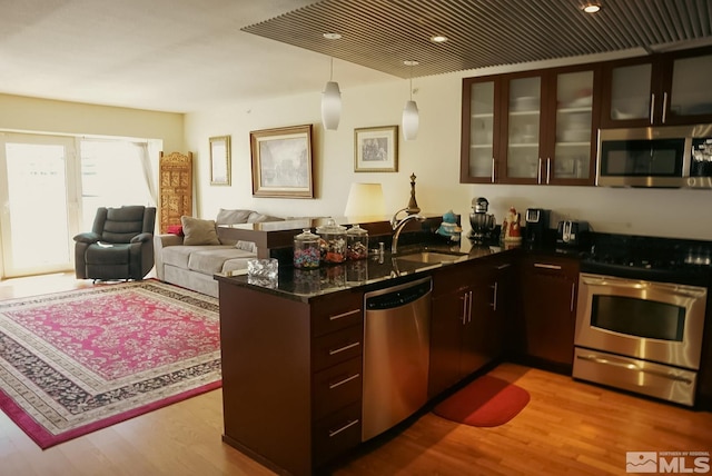 255 N Sierra St Unit 708, Reno, NV 89501 - kitchen with stainless steel appliances, a sink, a peninsula, wood finished floors, and glass insert cabinets