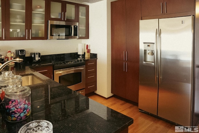 255 N Sierra St Unit 708, Reno, NV 89501 - kitchen featuring stainless steel appliances, a sink, light wood-style floors, and dark stone counters