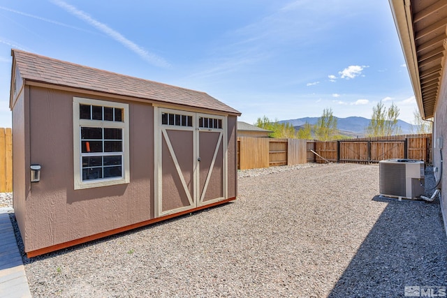 1180 Ferretto Pkwy, Dayton, NV 89403 - fenced backyard featuring central AC unit, a mountain view, a storage unit, and an outdoor structure