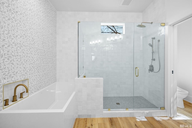 2531 Edgerock Rd, Reno, NV 89519 - bathroom featuring wood finished floors, wallpapered walls, toilet, a bath, and a stall shower