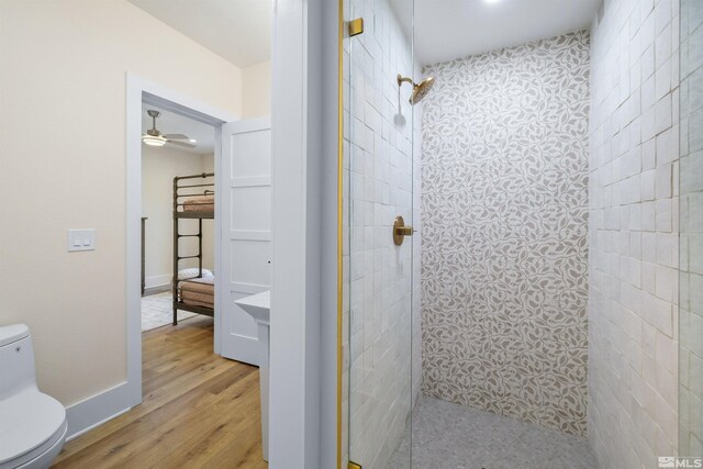 2531 Edgerock Rd, Reno, NV 89519 - bathroom with toilet, a tile shower, wood finished floors, baseboards, and ceiling fan