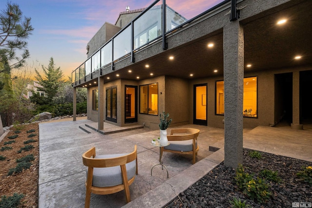 2531 Edgerock Rd, Reno, NV 89519 - back of house at dusk featuring stucco siding, a patio area, and a balcony