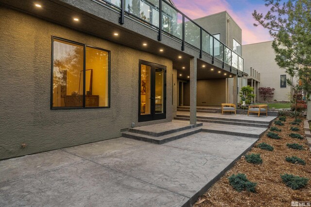 2531 Edgerock Rd, Reno, NV 89519 - exterior entry at dusk featuring a patio and stucco siding