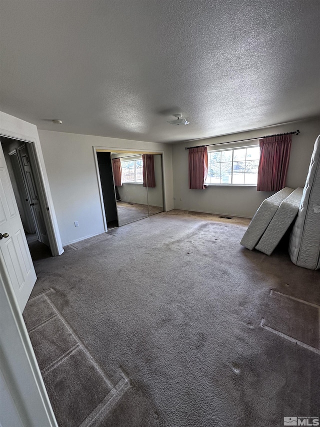 2037 Lonnie Ln, Dayton, NV 89403 - unfurnished bedroom with multiple windows, carpet floors, a textured ceiling, and a closet