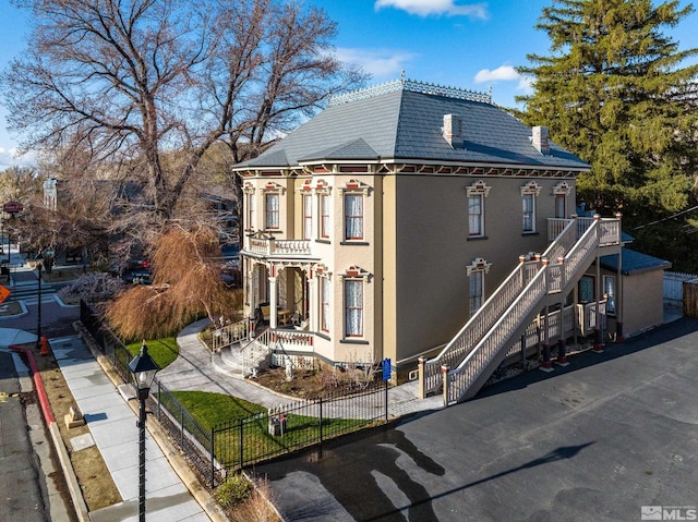 102 N Curry St, Carson City, NV 89703 - view of front of property with stairs, a fenced front yard, and stucco siding