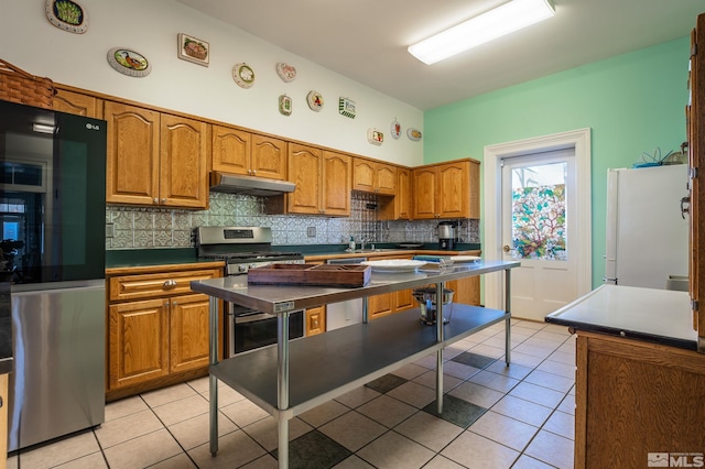 102 N Curry St, Carson City, NV 89703 - kitchen with appliances with stainless steel finishes, under cabinet range hood, light tile patterned flooring, and backsplash