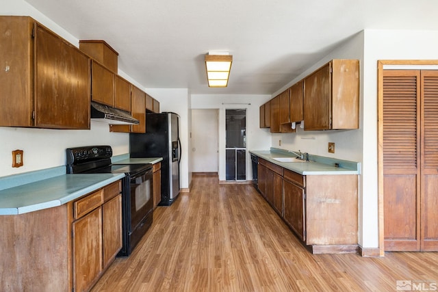 3301 Everett Dr, Reno, NV 89503 - kitchen with black appliances, a sink, under cabinet range hood, and light wood-type flooring