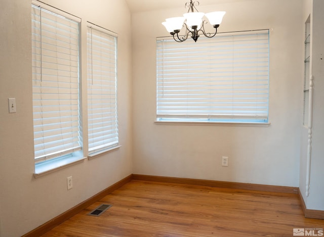 2621 Fanto Ct, Sparks, NV 89431 - unfurnished dining area with wood finished floors, a chandelier, and baseboards