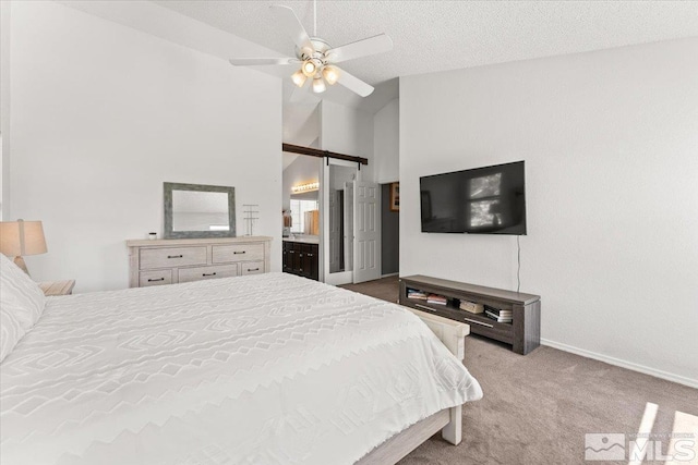 4776 Scenic Hill Cir, Reno, NV 89523 - carpeted bedroom featuring vaulted ceiling, baseboards, a barn door, ceiling fan, and ensuite bath