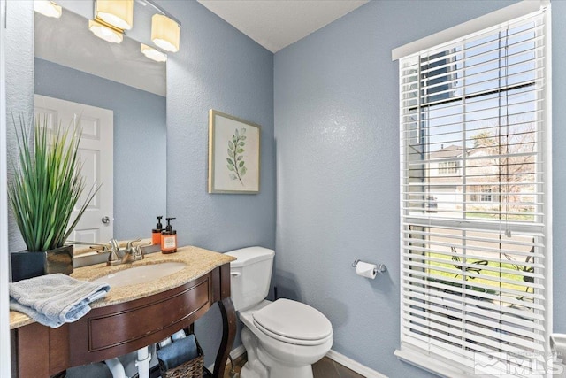 4776 Scenic Hill Cir, Reno, NV 89523 - half bathroom featuring toilet, baseboards, a textured wall, and vanity