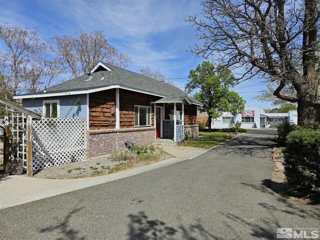 311 S Main St, Yerington, NV 89447 - bungalow-style house featuring brick siding, a shingled roof, and asphalt driveway