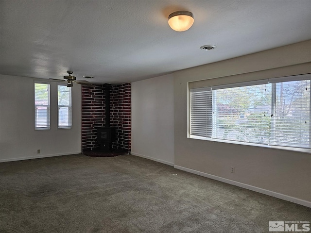 311 S Main St, Yerington, NV 89447 - spare room with a wood stove, carpet flooring, baseboards, and a ceiling fan