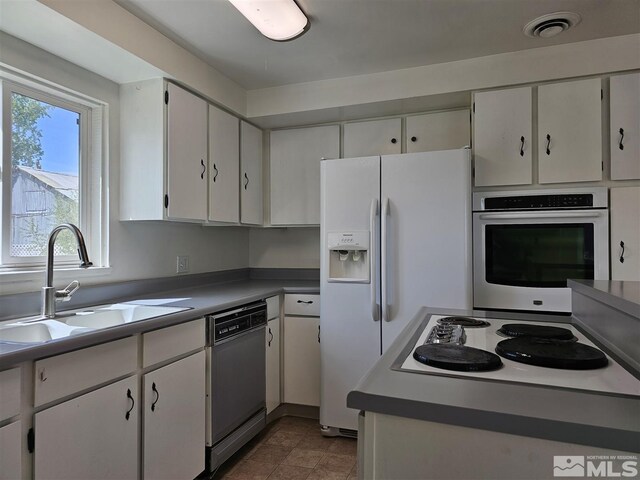311 S Main St, Yerington, NV 89447 - kitchen with white appliances, a sink, healthy amount of natural light, and white cabinetry