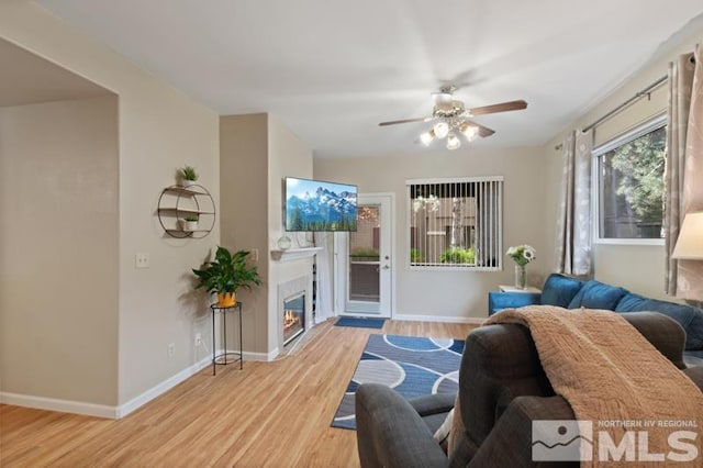 900 S Meadows Pkwy Unit 614, Reno, NV 89521 - living room with wood finished floors, baseboards, a ceiling fan, and a glass covered fireplace