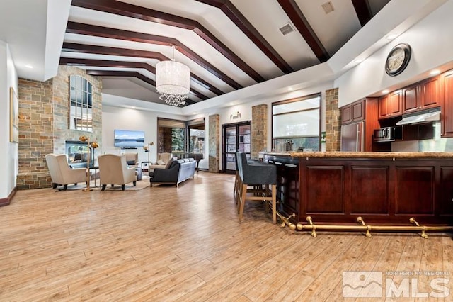 900 S Meadows Pkwy Unit 614, Reno, NV 89521 - kitchen with stainless steel appliances, light wood-style flooring, under cabinet range hood, open floor plan, and hanging light fixtures