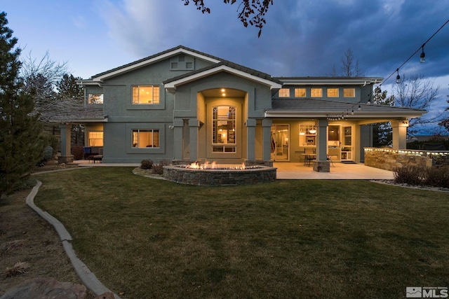 14245 Prairie Flower Ct, Reno, NV 89511 - rear view of property featuring a fire pit, a patio, stucco siding, and a lawn