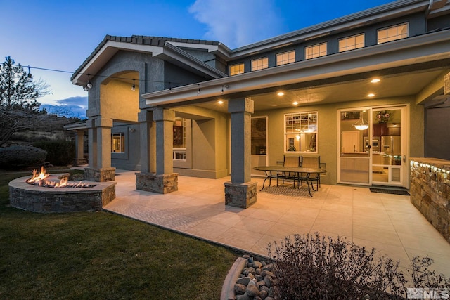 14245 Prairie Flower Ct, Reno, NV 89511 - rear view of house featuring a fire pit, a patio area, stucco siding, and a yard