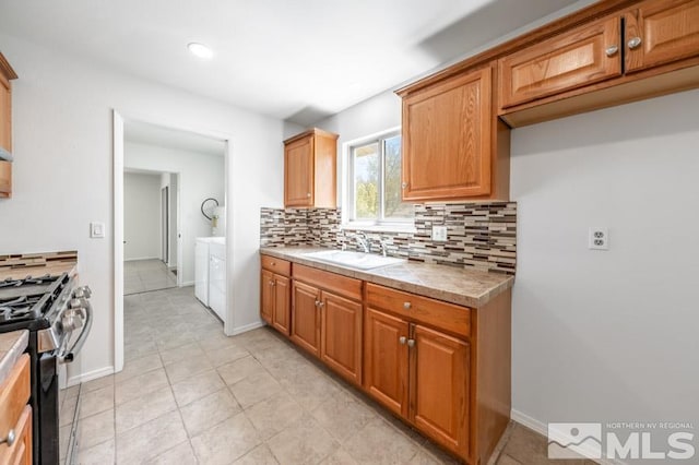 2441 Baxter, Sparks, NV 89431 - kitchen featuring gas range, a sink, washing machine and dryer, decorative backsplash, and tile counters