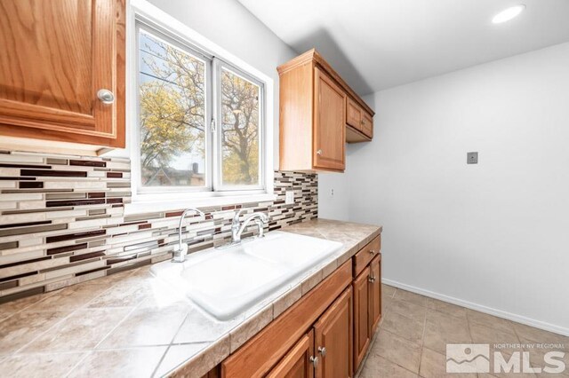 2441 Baxter, Sparks, NV 89431 - kitchen with a sink, tasteful backsplash, tile counters, baseboards, and brown cabinetry