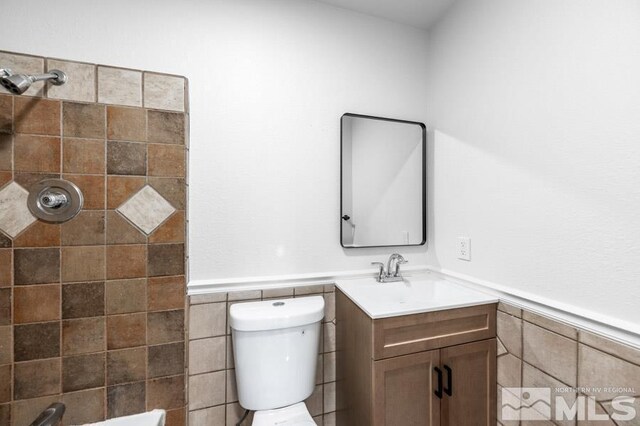 2441 Baxter, Sparks, NV 89431 - bathroom with wainscoting, vanity, tile walls, tiled shower, and toilet