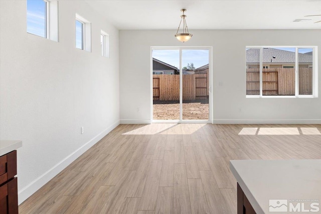 887 Agate, Fernley, NV 89408 - unfurnished dining area with light wood-style floors, healthy amount of natural light, and baseboards