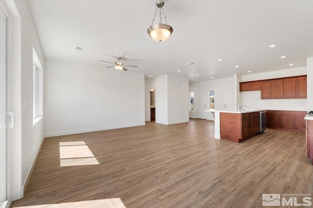 887 Agate, Fernley, NV 89408 - kitchen with open floor plan, light wood-type flooring, light countertops, a sink, and baseboards
