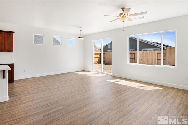 887 Agate, Fernley, NV 89408 - unfurnished living room with light wood-style floors, baseboards, and a ceiling fan