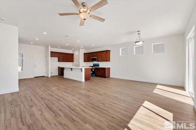 887 Agate, Fernley, NV 89408 - unfurnished living room featuring light wood-type flooring, baseboards, ceiling fan, and recessed lighting