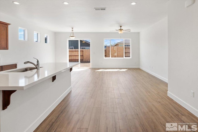 887 Agate, Fernley, NV 89408 - unfurnished living room featuring a sink, wood finished floors, baseboards, a ceiling fan, and recessed lighting