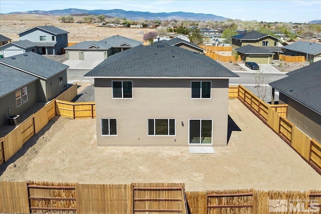 887 Agate, Fernley, NV 89408 - rear view of property featuring a residential view, a fenced backyard, stucco siding, a shingled roof, and a mountain view