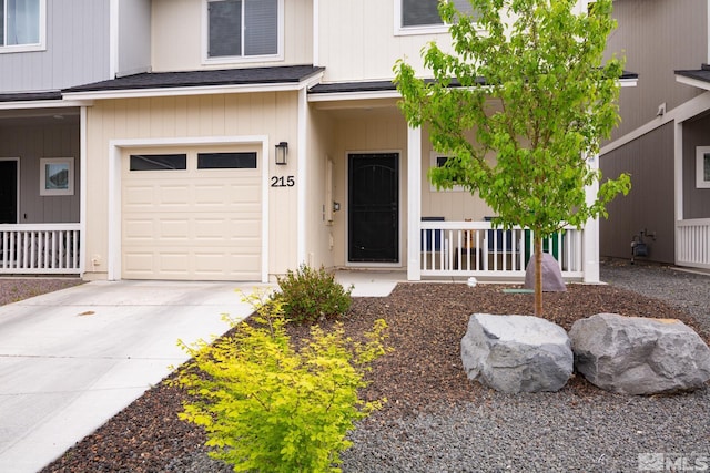 215 Goss Pl, Dayton, NV 89403 - view of exterior entry with a porch, a garage, driveway, and a shingled roof