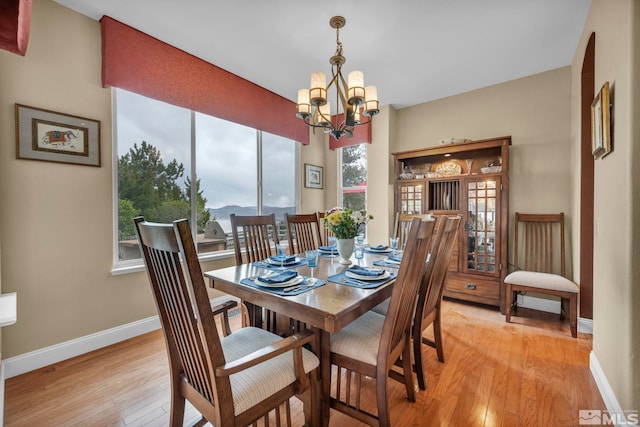 3463 White Mountain Ct, Reno, NV 89511 - dining area featuring light wood-style flooring, baseboards, and a chandelier