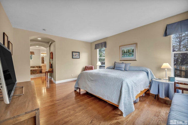 3463 White Mountain Ct, Reno, NV 89511 - bedroom with light wood finished floors, arched walkways, and baseboards